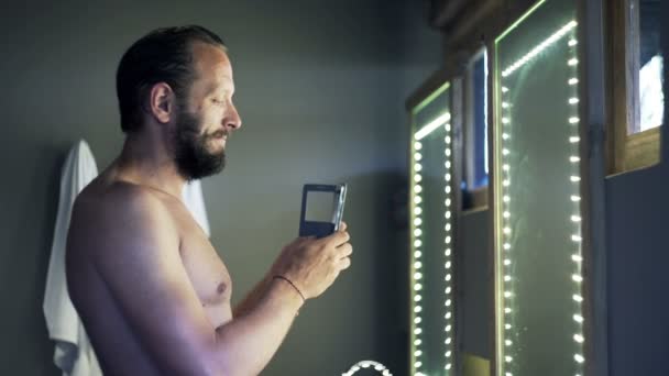 Man taking selfie photo with cellphone in bathroom — Stock Video