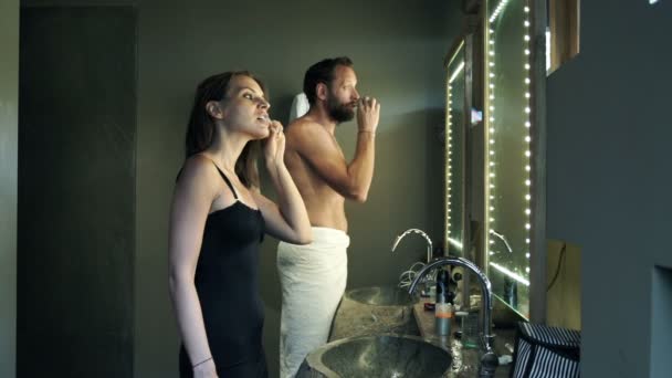 Jovem casal escovar os dentes no banheiro — Vídeo de Stock