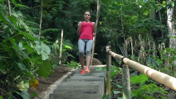 Красивая женщина бегает по лестнице в парке — стоковое видео