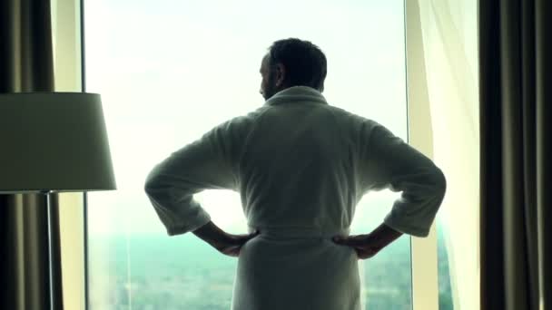 Man in bathrobe admire view from window — Stock Video