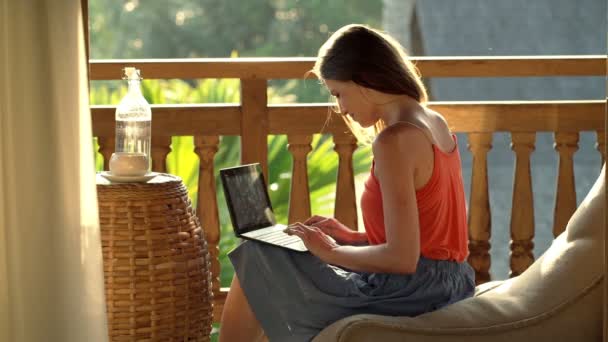 Γυναίκα χρησιμοποιώντας φορητό υπολογιστή ενώ κάθεται στην βεράντα — Αρχείο Βίντεο