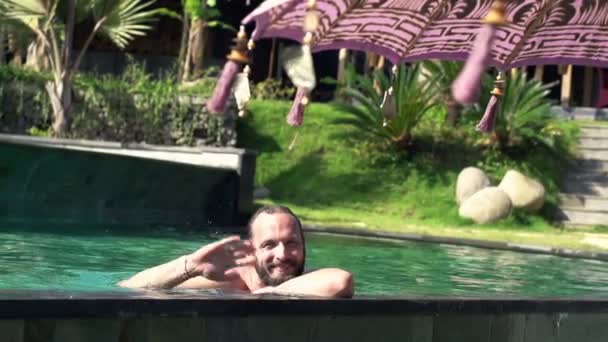 Hombre feliz saludando a la cámara en la piscina — Vídeos de Stock