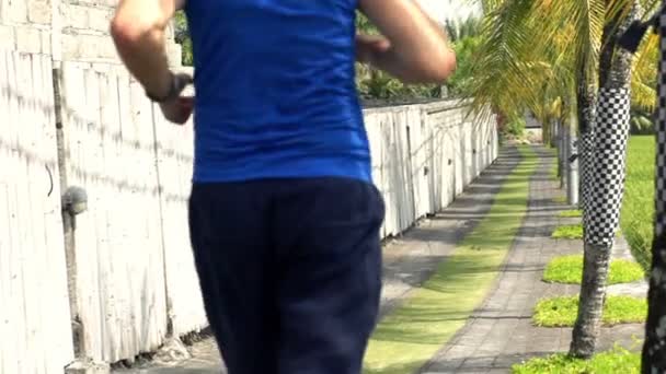 Young man jogging on path in country — Stock Video
