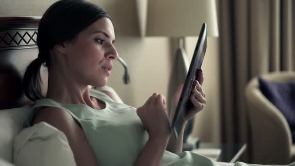 Affärskvinna med hjälp av Tablet PC: n liggande på sängen — Stockvideo