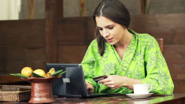 Woman doing online shopping on laptop in kitchen — Stock Video