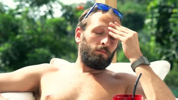 Un bărbat care bea cocktail la soare lângă piscină — Videoclip de stoc