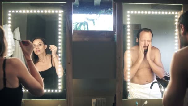 Mann wäscht sich die Hände und Frau trägt Mascara auf — Stockvideo