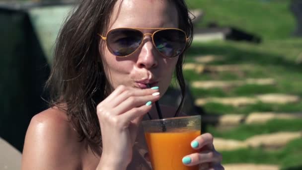 Vrouw zonnebaden en cocktail drinken in de tuin — Stockvideo