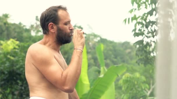 Uomo che si lava i denti sulla terrazza — Video Stock