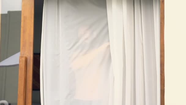 Homem feliz desvendar cortinas no quarto — Vídeo de Stock