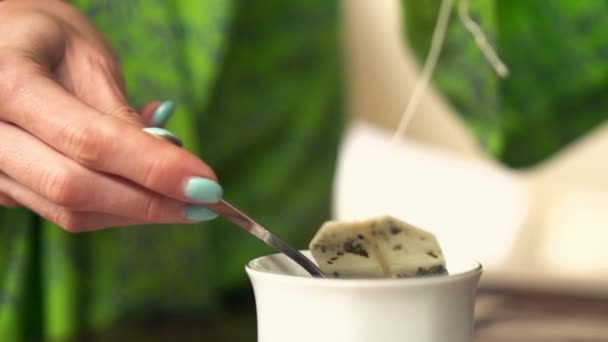 Woman making tea in cup and taking out teabag — Stock Video