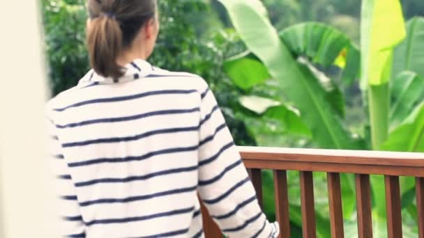 Frau geht auf Terrasse und streckt Arme aus — Stockvideo