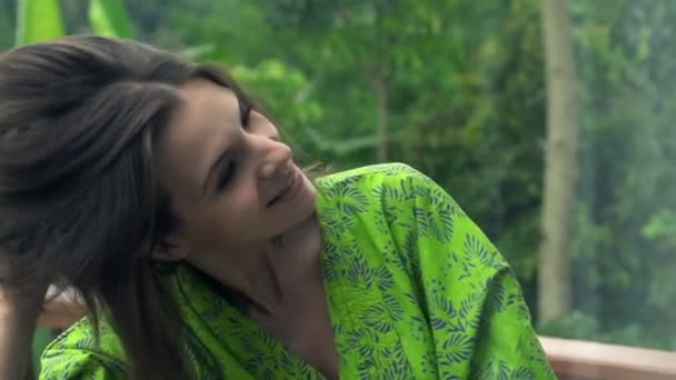 Mujer aplicando laca en el cabello en la terraza — Vídeos de Stock