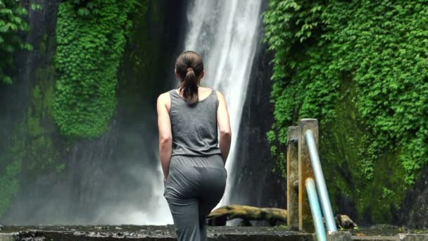 Mujer caminando cerca de cascada en Bali — Vídeos de Stock