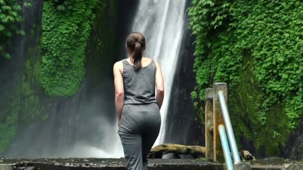 Mujer caminando cerca de cascada en Bali — Vídeos de Stock