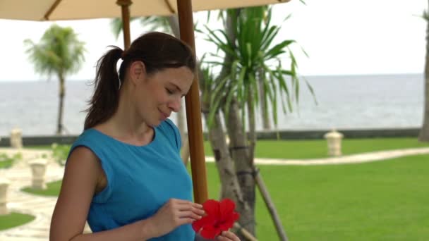 Грустная женщина с цветами в саду — стоковое видео