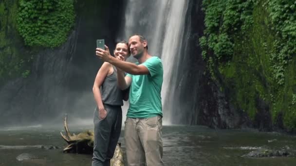 Couple taking photo by waterfall — Stock Video