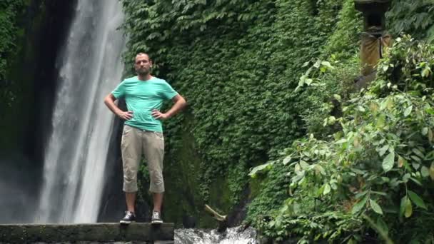 Man standing by beautiful waterfall — Stock Video