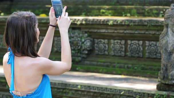 Femme prenant des photos avec de la sculpture ancienne — Video