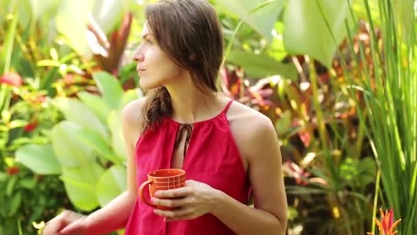 Жінка п'є чай в саду — стокове відео