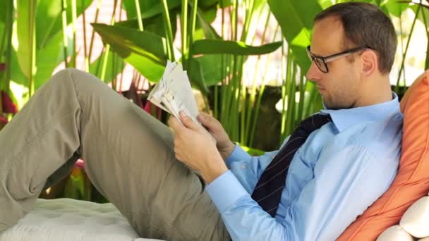 Businessman reading newspaper in gazebo — Stock Video