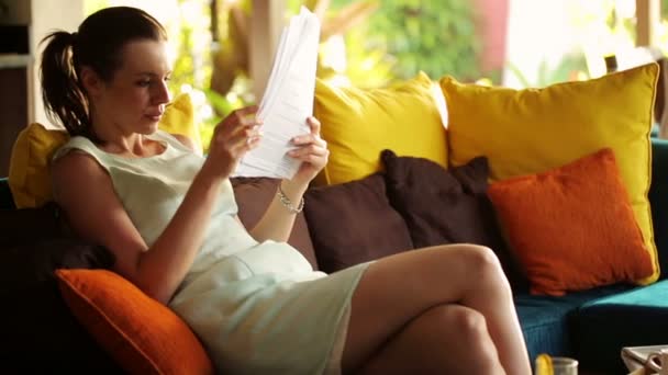 Geschäftsfrau liest Dokumente auf dem Sofa — Stockvideo