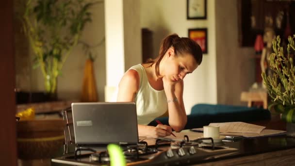 Empresaria escribiendo notas en documentos en la cocina — Vídeos de Stock