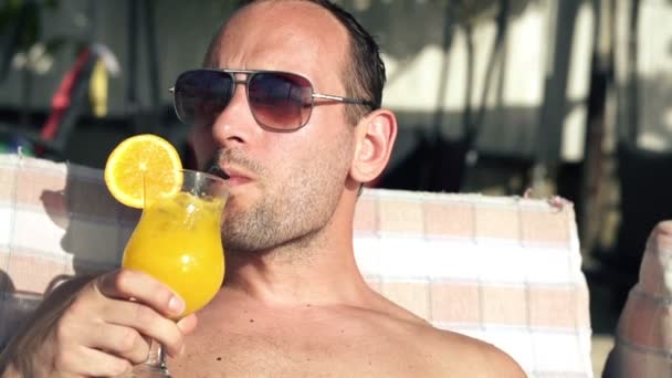 Mann trinkt Cocktail auf Sonnenbank — Stockvideo