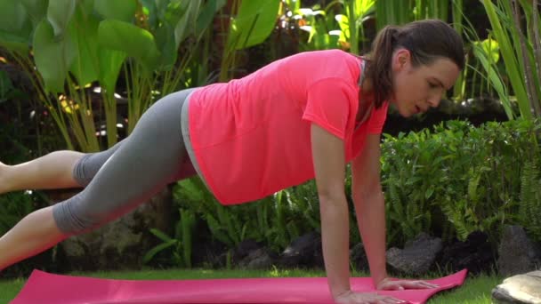 Jeune femme exerçant sur le tapis — Video