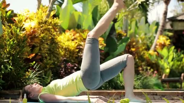 Mulher exercendo na plataforma no jardim — Vídeo de Stock