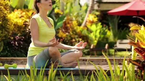 Mujer atractiva meditando en el jardín — Vídeo de stock