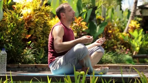 Man meditating in garden — Stock Video