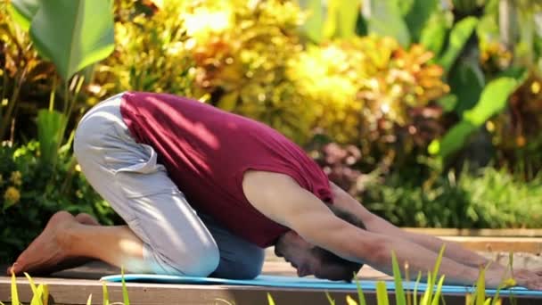 Young man stretching in the garden — Stock Video