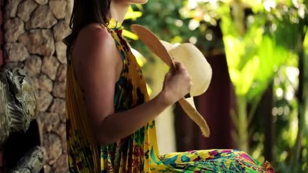Жінка охолоджує себе капелюхом на лавці — стокове відео