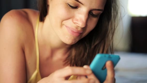 Žena textilie na smartphone na posteli — Stock video