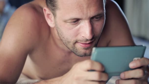 Mann mit Smartphone im Bett liegend — Stockvideo