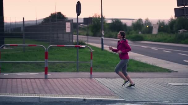 Жінка біжить в місті ввечері — стокове відео