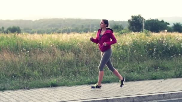 Молода жінка біжить у сільській місцевості — стокове відео