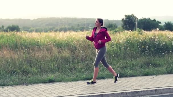 Jeune femme jogging dans la campagne — Video