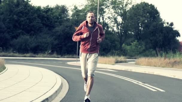 Man jogging på asfalterad väg — Stockvideo