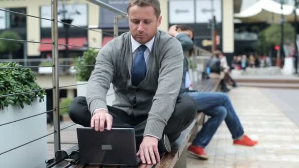 Geschäftsmann beendet die Arbeit am Laptop und entspannt sich in der Stadt — Stockvideo