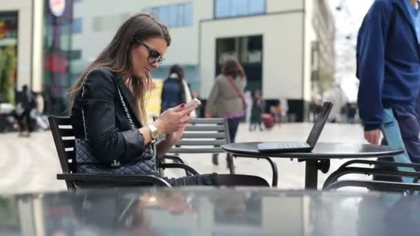 Mulher elegante enviando SMS, mensagens de texto no café na cidade — Vídeo de Stock