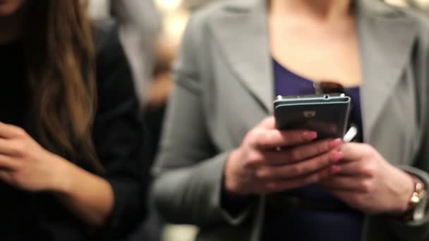 Businesswomen con teléfono inteligente a caballo metro tren — Vídeos de Stock