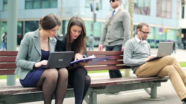Geschäftsleute, die in der Stadt mit Laptop und Dokumenten arbeiten — Stockvideo