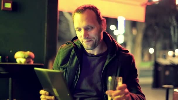 Hombre con Tablet PC bebiendo cerveza en el bar — Vídeos de Stock