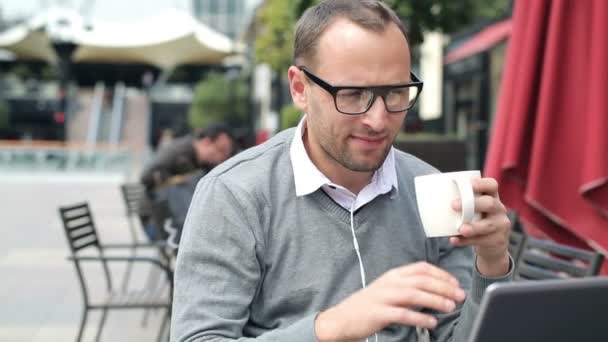 Gelukkig aantrekkelijke jongeman zitten in Cafe — Stockvideo