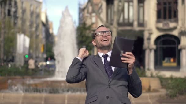 Успешный бизнесмен с планшетным компьютером в городе — стоковое видео
