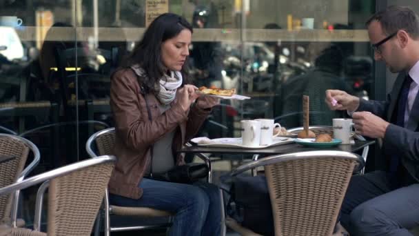 Молодая пара ест и разговаривает во время обеда в кафе в городе — стоковое видео