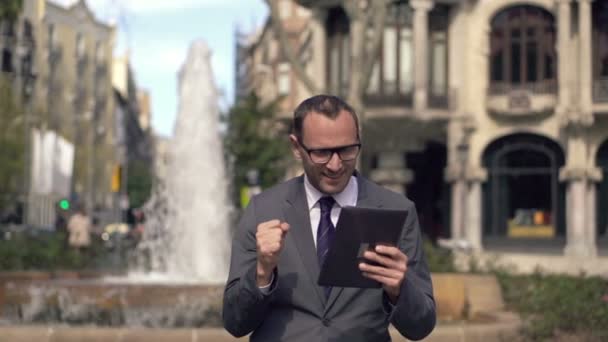 Успешный бизнесмен с планшетным компьютером в городе — стоковое видео