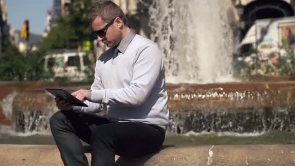 Бізнесмен, що працює на планшетному комп'ютері в місті — стокове відео
